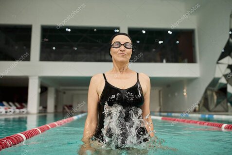 インストラクターの指導のもと温水プールで運動する高齢者たち