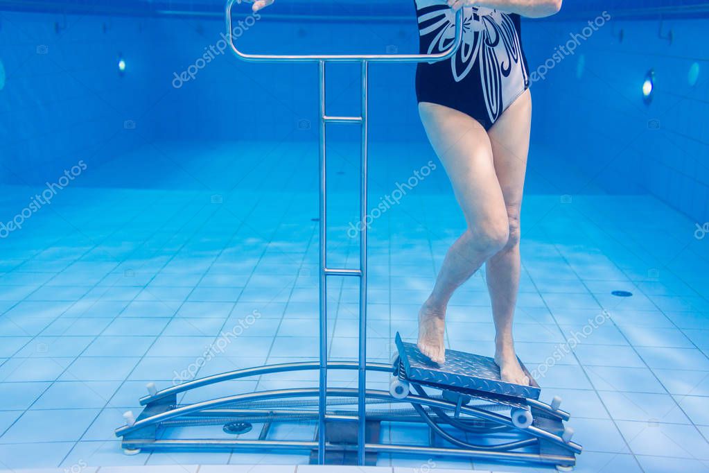 温水プールでインストラクターとともに運動する入居者